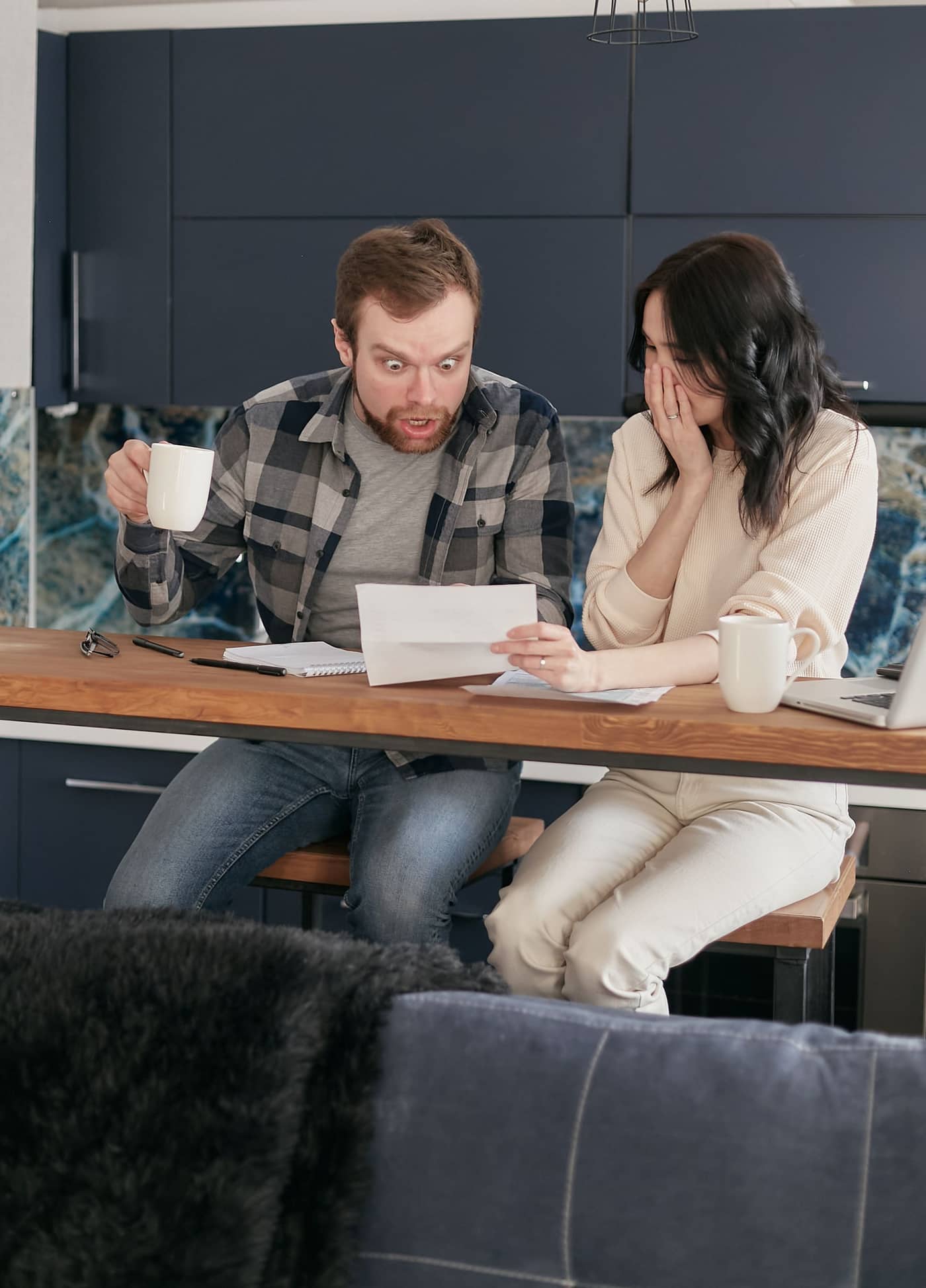 A couple at the kitchen table reading a letter from the tax office