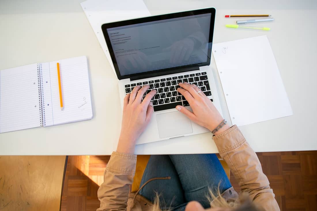 Someone working at home on a laptop with documents